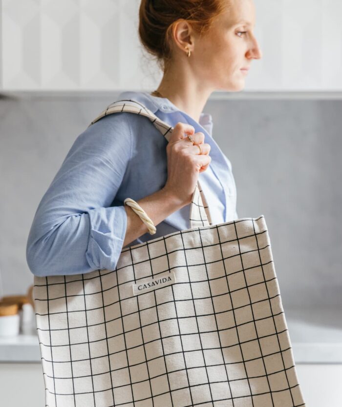 Anne-Sophie Vidal, fondatrice de Casavida, portant à l'épaule L'Irremplaçable Cabas Carreaux de Casavida, sac cabas en coton bio