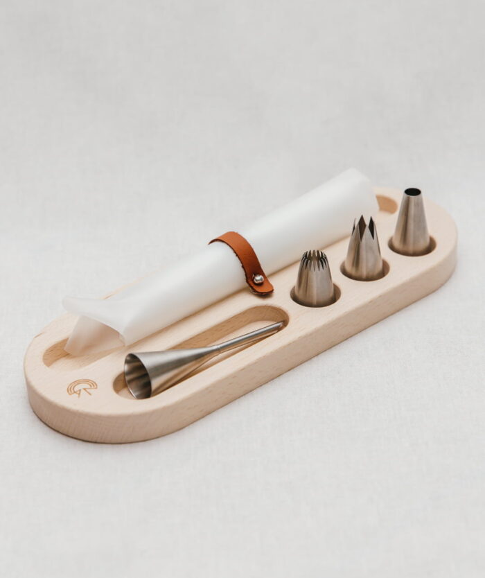 Poches et douilles en inox rangées sur le socle en bois de L'Élite du Pochage de Casavida
