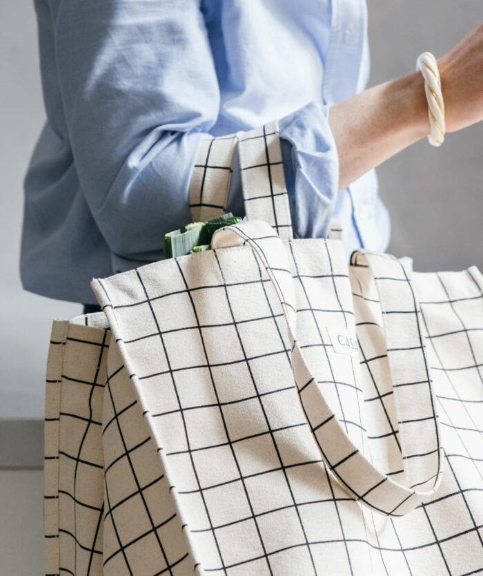 Femme portant à l'épaule L'Irremplaçable Cabas Carreaux de Casavida, sac cabas en coton bio à double anses
