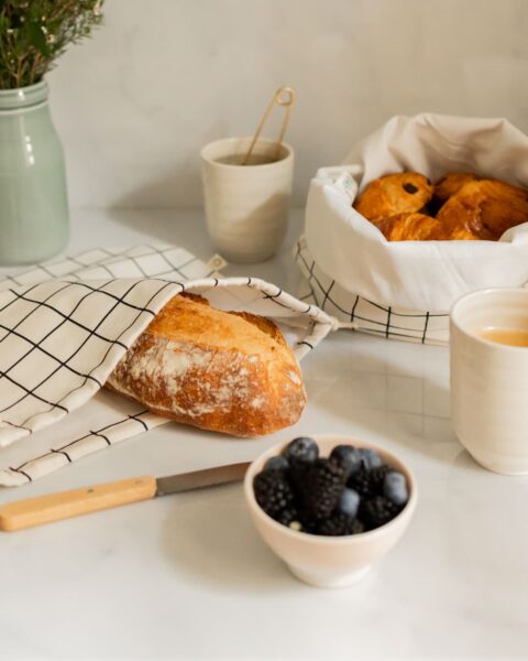 Petit-déjeuner avec La Sache à Pains de Casavida, sac à pain réutilisable en coton à carreaux et viennoiseries