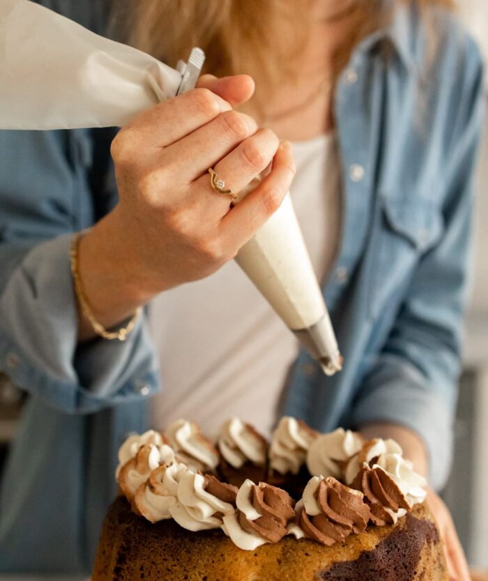 Ganache pochée sur un gâteau avec la poche à douille réutilisable de L'Élite du Pochage de Casavida