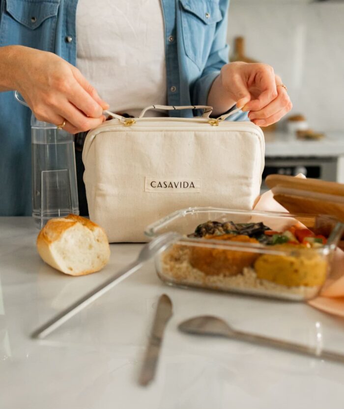 Femme fermant Le Vanity Cool de Casavida avec une boîte repas et des couverts, lunchbox isotherme en jute