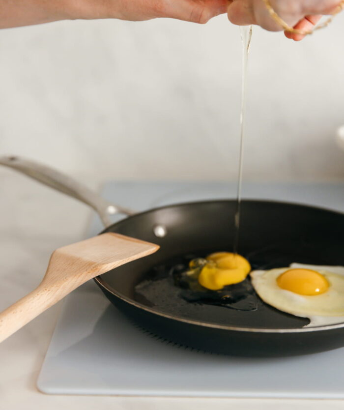 La Palette Coudée de Casavida à côté d'œufs au plat en cuisson dans une poêle