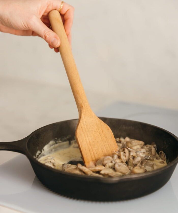 La Palette Habile de Casavida remuant des champignons dans une poêle, spatule en bois de hêtre