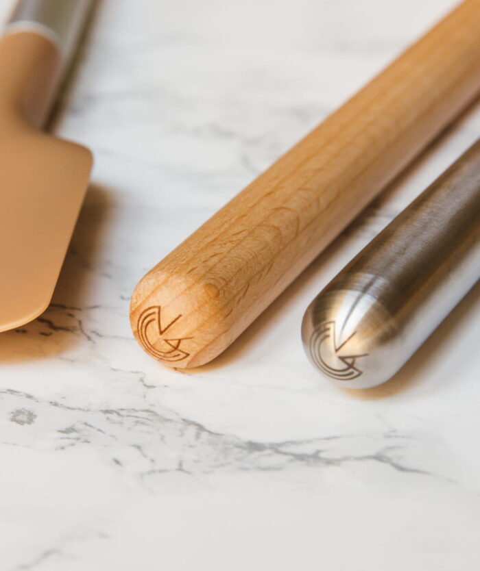 Détail du manche gravé de La Palette Coudée de Casavida en bois de hêtre et d'un ustensile en inox Casavida