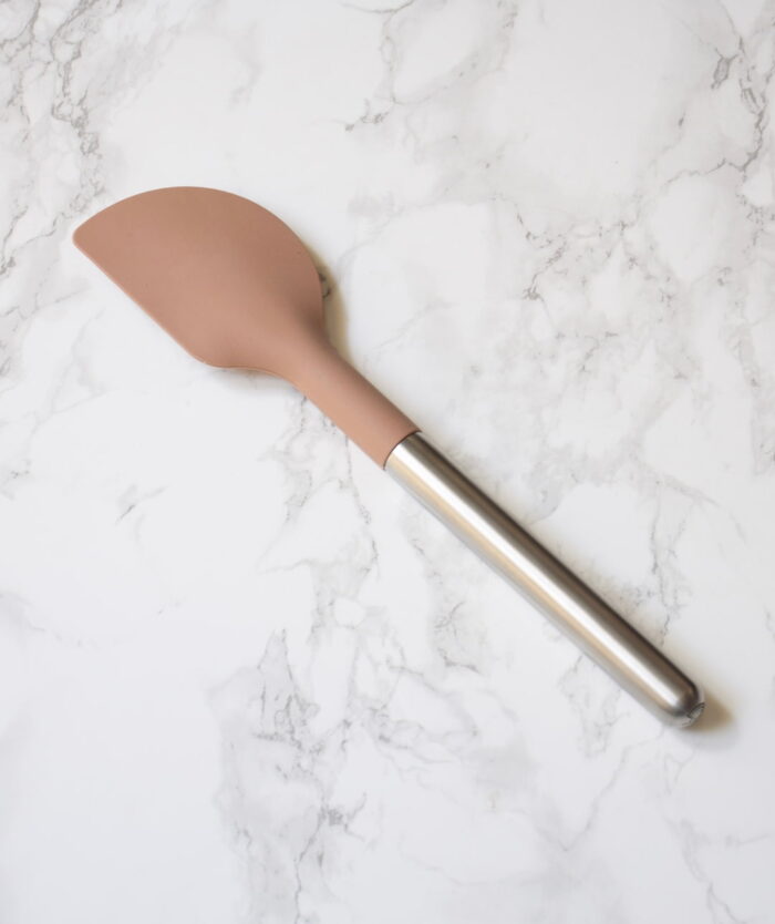 La Maryse Consciencieuse de Casavida, maryse en silicone platinium et manche inox sur un plan de travail en marbre