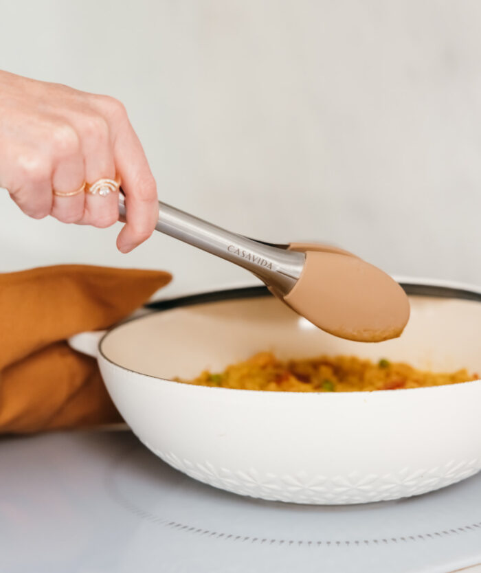 La Pince Agile de Casavida servant un plat dans une cocotte, pince de cuisine en inox et silicone