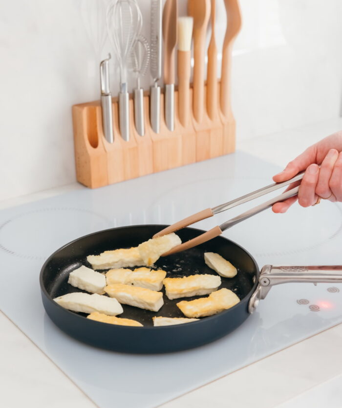 La Pince Agile de Casavida retournant des aliments dans une poêle antiadhésive