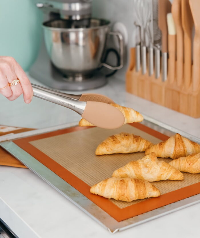 La Pince Agile de Casavida attrapant un croissant sur une plaque de cuisson en silicone